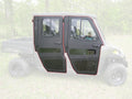 A Polaris Ranger Mid Size 570 Crew (2014-2021) with Full Steel Doors by Armor Tech is shown in profile. The black, angular doors feature large windows and red outlines. Background elements like grass and trees appear faded.