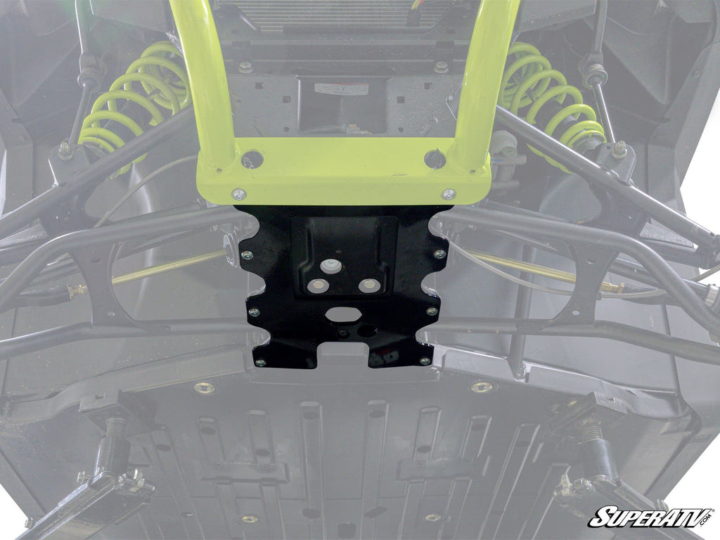 Close-up view of a Bobcat UV34 displaying suspension components, skid plate, A-arms, yellow shocks, and metal frame. The SuperATV logo appears in the lower right. The image highlights the central front area with the Frame Stiffener installed.