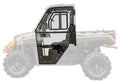 The Polaris Ranger XP Kinetic Convertible Cab Enclosure Doors are shown with a black frame, clear panels, handle, and hinges superimposed on the side of an off-road Polaris Ranger to illustrate their fit on the vehicle’s cab.