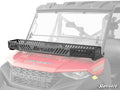A Polaris Ranger XP Kinetic Hood Rack Bravo is mounted on the roof edge of a red Polaris Ranger 1000 utility vehicle, featuring vented slats and branding, with the windshield and front hood visible behind.