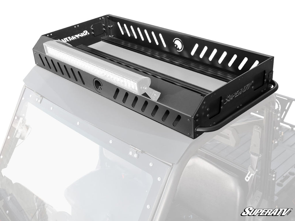 A Polaris Ranger XP 1000 Outfitter Roof Rack, made of black metal with cut-out slots and a mounted LED light bar, is installed above the off-road vehicle’s front seats. The SuperATV-labeled rack is partially visible in a transparent overlay.