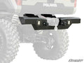 A Polaris Ranger XP Kinetic Winch-Ready Rear Bumper with LED lights and a winch hook is mounted on an off-road vehicle. The setup features large rugged tires and exposed suspension springs, with the SuperATV logo displayed in the lower right corner.