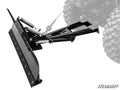 The Polaris Ranger 1000 Plow Pro Snow Plow, featuring a wide curved black metal blade, heavy-duty springs, and a mounting bracket, is mounted on the front of an off-road vehicle. The SuperATV logo appears in the bottom right corner.