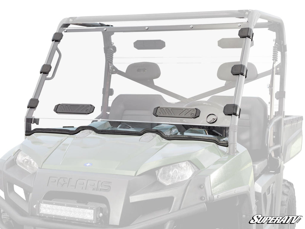 A Polaris Ranger Full-Size 570 Vented Full Windshield with black mounts is installed on a green Polaris utility vehicle. The windshield has two adjustable vent panels near the bottom center and displays the SuperATV logo in the lower right corner.