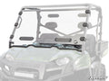 A Polaris Ranger Full-Size 570 Vented Full Windshield with black mounts is installed on a green Polaris utility vehicle. The windshield has two adjustable vent panels near the bottom center and displays the SuperATV logo in the lower right corner.