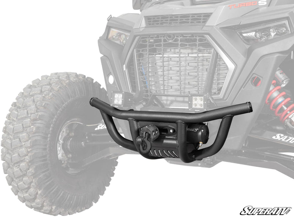 The Polaris RZR XP Turbo S Winch-Ready Front Bumper, shown in black with angled bars and a mesh center, is displayed with a tow hook and winch against a faded ATV background. SuperATV branding is visible in the lower right corner.