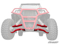 Red Polaris RZR Trail S 1000 High Clearance 1.5 Forward Offset A-Arms are highlighted on the front end of an off-road vehicle with large tires and a bumper, fading out the vehicle to showcase the new suspension. The SuperATV logo is in the bottom right.