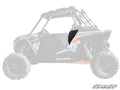 A Polaris RZR Side Panel in black metal is installed on the drivers side door of a Polaris RZR. The mostly faded vehicle emphasizes the panel, with the SuperATV logo visible in the lower right corner of the image.