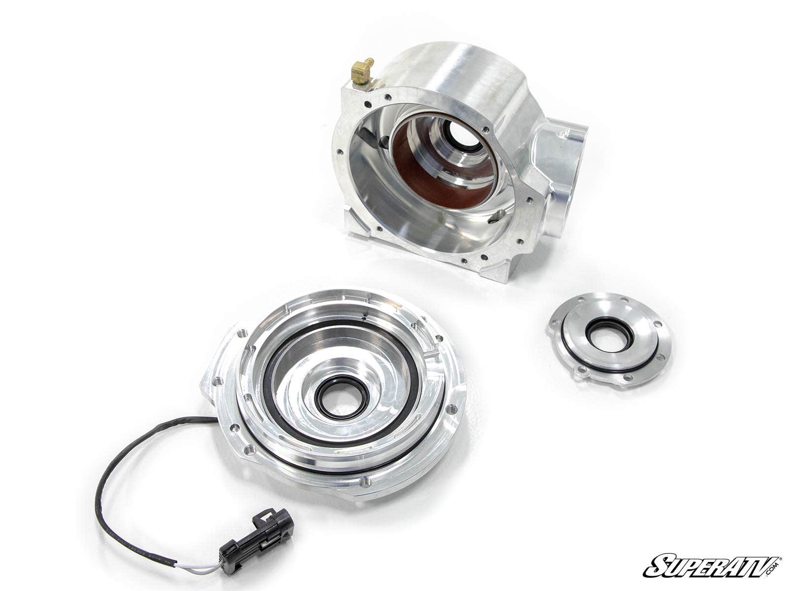 Three machined metal parts, including a sensor-wired component, a large housing with bronze interior, and a small circular piece, are arranged on a white surface. The SuperATV logo appears at the bottom right. Product: Polaris Ace Heavy-Duty Front Differe