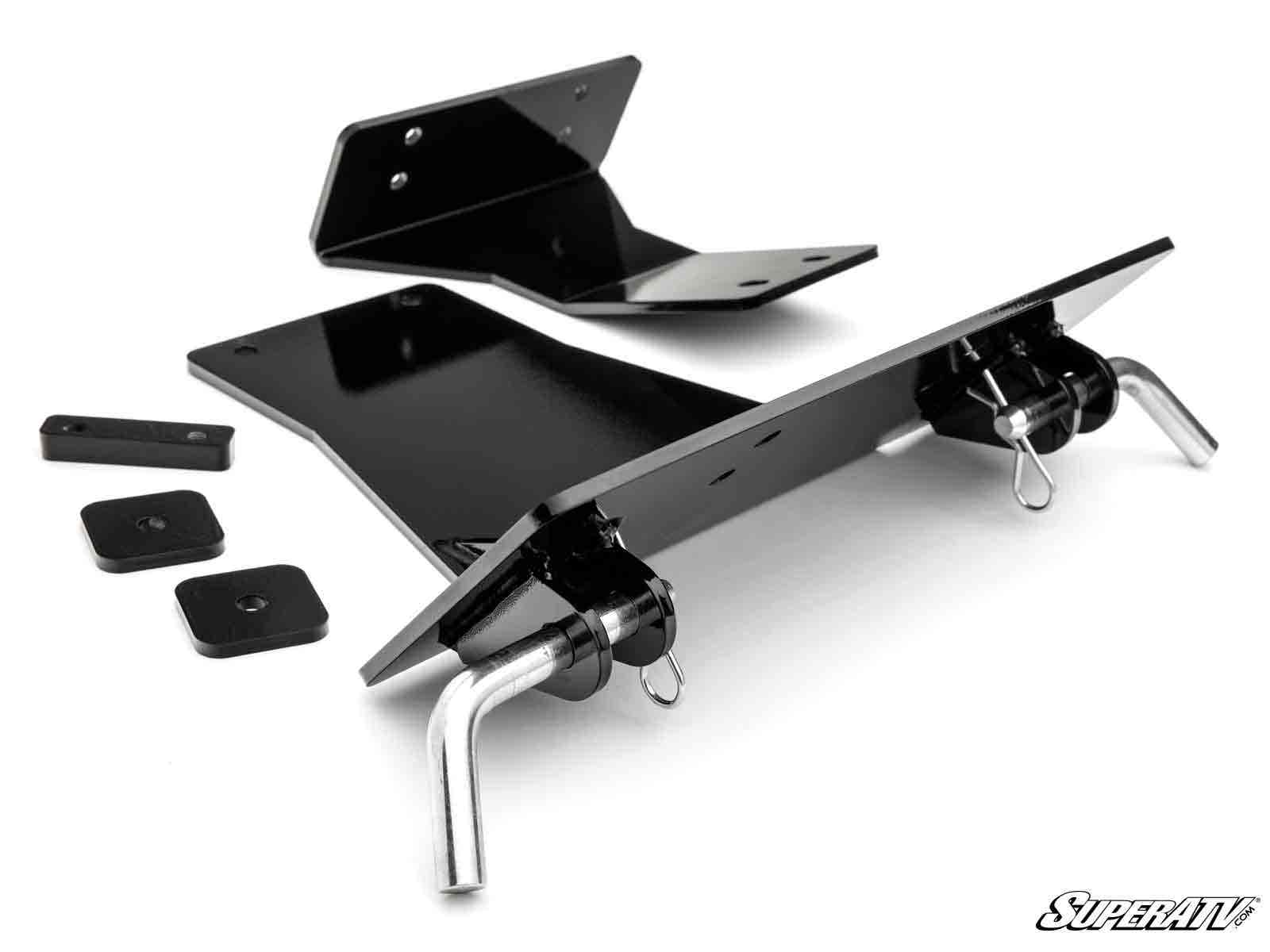 A Polaris RZR XP 900 Plow Pro Snow Plow Mount kit in black metal, featuring two main angled plates, two pins with clips, and three small rectangular plates with a glossy finish, all neatly arranged on a white background.