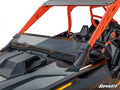 A close-up of a black and orange off-road vehicle with open seating and an angular, modern design showcases the Polaris RZR Turbo R Half Windshield installed. The SuperATV logo appears at the bottom right, set against a plain white background.