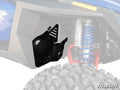 A close-up of a Polaris RZR PRO XP Inner Fender Guard shows a large tire, coiled blue shock absorber, and black metal guard with vent slits protecting suspension parts. The SuperATV logo appears in the bottom right corner.