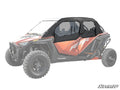 A Polaris RZR Turbo R 4 with bold red and black body, featuring RZR and POLARIS branding, is shown equipped with Primal Soft Cab Enclosure Upper Doors. Large rugged tires stand out as the background and rest of the vehicle are faded.