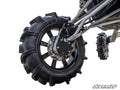 Close-up of a Polaris RZR RS1 8 Portal Gear Lift featuring a large off-road wheel with aggressive tread, black alloy rim, and visible suspension and brake components. A smaller wheel appears in the back. SuperATV logo shown on a white background.