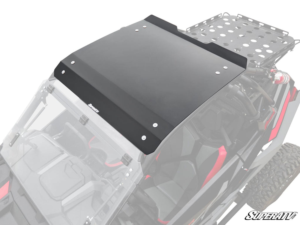 A Polaris RZR Turbo R Aluminum Roof, black and rectangular, is installed on a side-by-side off-road vehicle with red interior accents and a rear metal cargo rack. Secured with bolts, the SuperATV logo appears in the corner, viewed from above at an angle.