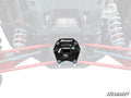 A close-up of a black Polaris RZR RS1 Rear Receiver Hitch mounted on the rear of an off-road vehicle, centered between red suspension arms and silver shocks. The background is faded, with the SuperATV logo in the bottom right corner.