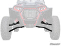 The image shows the front view of an off-road ATV featuring black Polaris RZR XP Turbo S High Clearance Front A-Arms labeled SuperATV, which stand out clearly. The rest of the vehicle is faded, and the SuperATV logo appears at the bottom right corner.