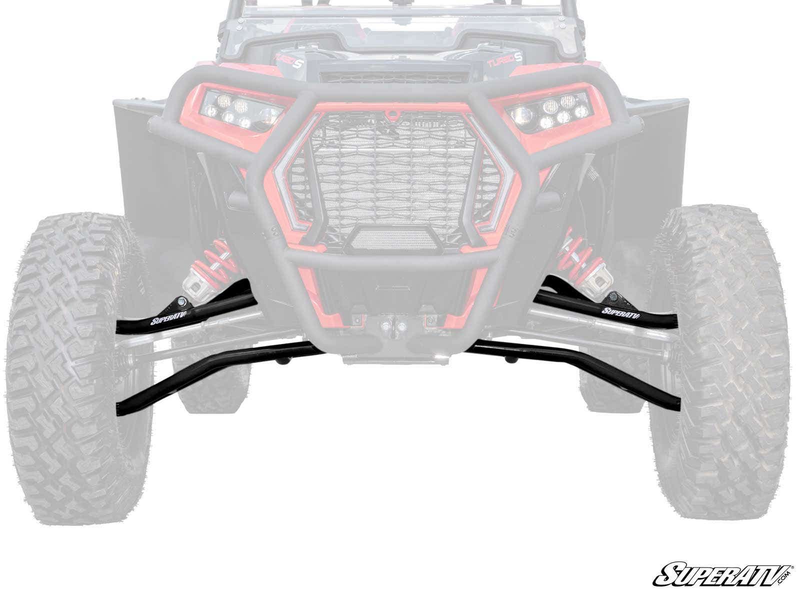 The image shows the front view of an off-road ATV featuring black Polaris RZR XP Turbo S High Clearance Front A-Arms labeled SuperATV, which stand out clearly. The rest of the vehicle is faded, and the SuperATV logo appears at the bottom right corner.