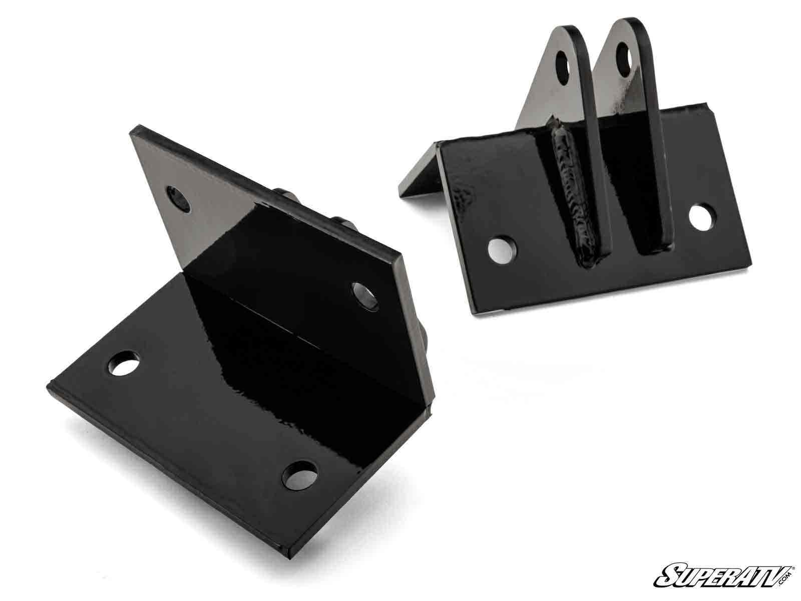 The Polaris RZR XP Plow Pro Snow Plow Mount is shown: two black metal brackets with a glossy finish, bolt holes, and angled flanges—one has upright tabs with holes, the other has flat surfaces. SuperATV logo appears in the bottom right corner.