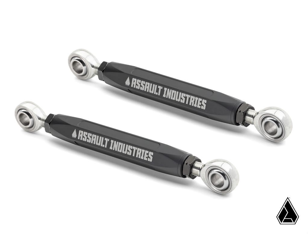 Two black metal Assault Industries Turret Rear Sway Bar End Links for Polaris RZR Pro XP with silver spherical rod ends and branding, diagonally positioned on white. Assault Industries triangular logo shown bottom right.