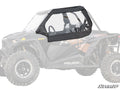 A set of Polaris RZR XP 1000 Primal Soft Cab Enclosure Upper Doors, featuring black soft sides and clear plastic windows, is installed on the side of an off-road vehicle, covering the cabin and revealing the seats and steering wheel inside.