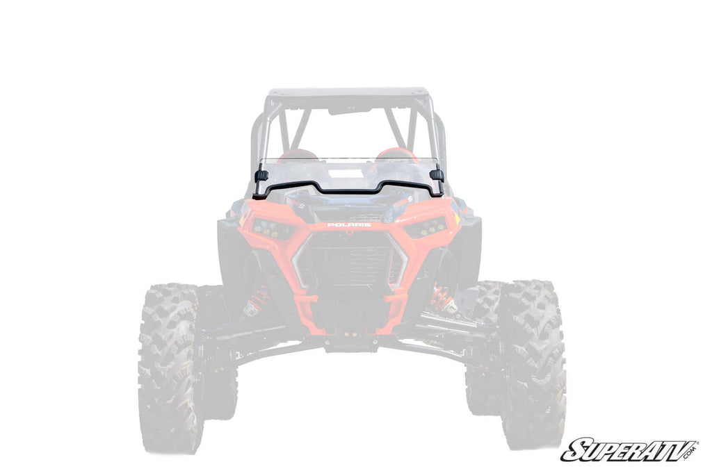 A front view of a red Polaris off-road vehicle is shown with a Polaris RZR Turbo S Half Windshield installed. The background and vehicle are faded to highlight the windshield, with “SuperATV” branded in the lower right corner.