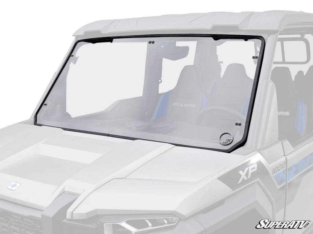 A Polaris Xpedition Full Windshield is installed on a white Polaris XP 1000 with black framing, showing two blue-accented bucket seats. The SuperATV logo appears in the bottom right corner of the image.