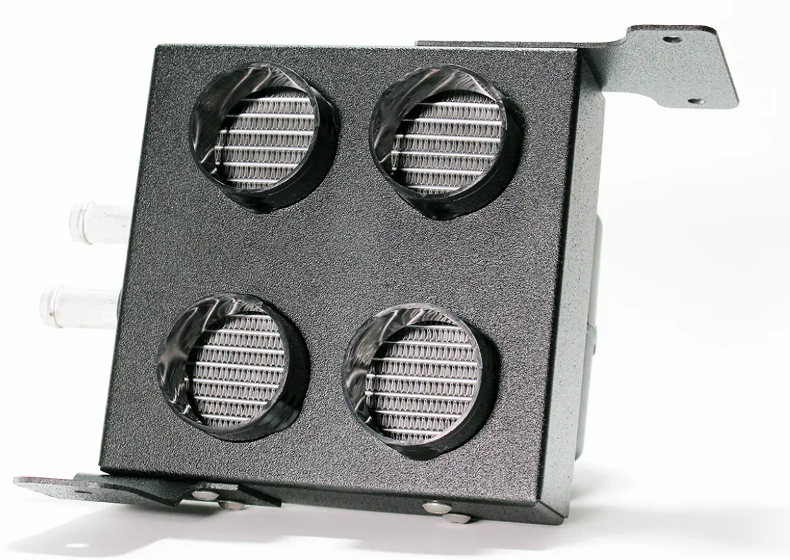 The Inferno Cab Heater Kit With Defrost for 2015-Current Kawasaki Mule Pro FX/FXT/FXR is a rectangular black metal box with four circular vent grilles, two short hose connectors on the left, and mounting brackets on top right and bottom left.
