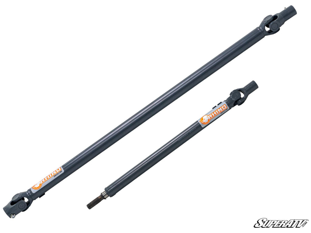 Two gray metal Can-Am Defender Heavy-Duty Prop Shaft Rhino Driveline prop shafts of different lengths are side by side on a white background. Both have yokes and orange Rhino labels, with the lower shaft featuring a splined end. SuperATV logo appears at b
