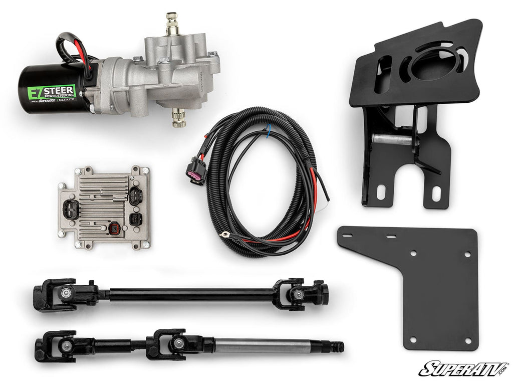An overhead view of the Polaris RZR PRO XP Power Steering Kit, featuring a motor, two mounting brackets, wiring harness, control module, and two black steering linkages arranged on a white background. The “SuperATV” logo is visible in the corner.