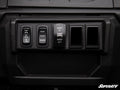 Close-up of a rugged dashboard panel with four black switches—differential lock, mode selector, winch control, and two blanks—featuring Polaris Ranger 1000 Rocker Switch Adapters. The SuperATV logo appears in the lower right corner.