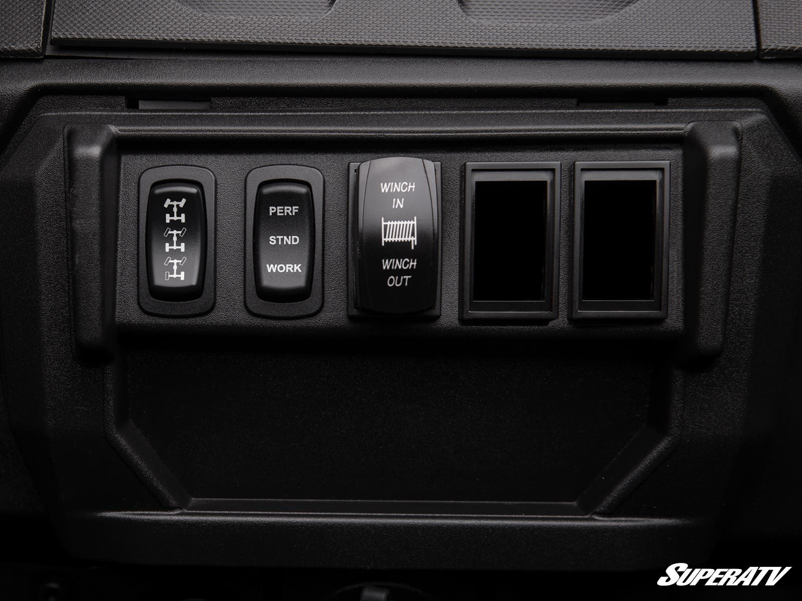 Close-up of a rugged dashboard panel with four black switches—differential lock, mode selector, winch control, and two blanks—featuring Polaris Ranger 1000 Rocker Switch Adapters. The SuperATV logo appears in the lower right corner.