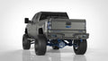 A lifted gray Silverado is shown in a studio with oversized off-road tires, blue accents, and a 2015-2019 Chevy/GMC 2500 Identity Rear Bumper Full Kit featuring shackle end pods, rings, and black accent lights.