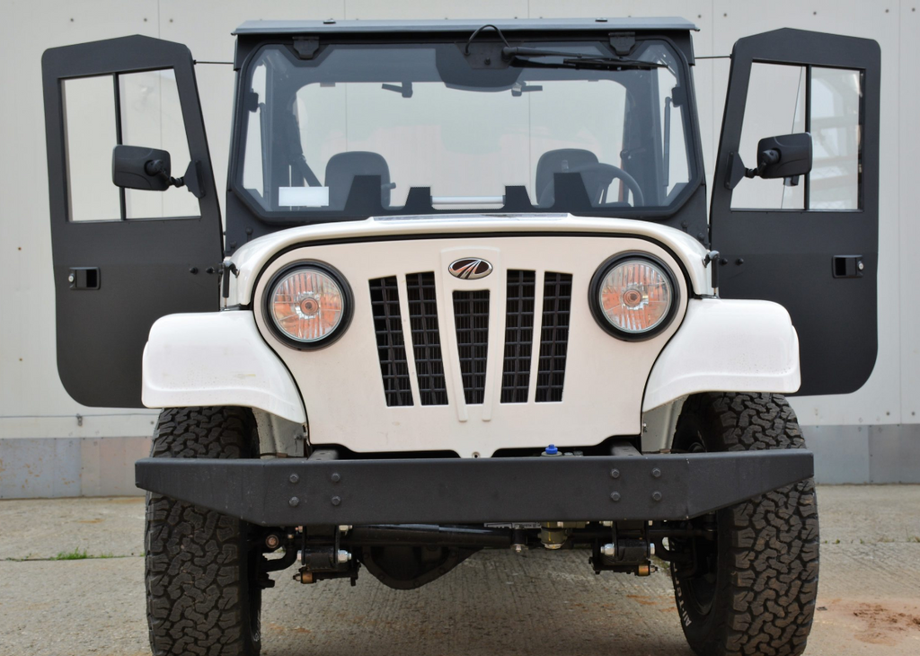 The ROXOR2 Full Hard Enclosure Cab Kit by Hardcabs is shown on a white off-road vehicle, front view, with both doors open. Features include round headlights, black grille, rugged tires, and Mahindra logo; background is plain with concrete ground.