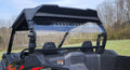 A close-up of the rear side of a black CFMoto ZForce 800 Trail/950 Sport & Trail with a 1 Piece Lexan Back Panel, roll cage, and two seats. The background features a grassy field and leafless trees under a blue sky.