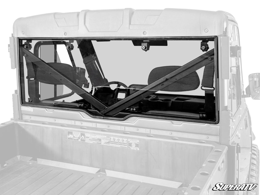 Rear view of a Gravely Atlas JSV with its rear windshield installed, featuring a black frame and X-shaped support bars. The cab interior and cargo bed are visible, shown with a partially grayscale effect.