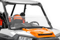 A front close-up of a Polaris RZR XP 1000 (2014-18) with a Rough Country Half Windshield (scratch-resistant); the clear windshield, visible roll cage, orange and black seat upholstery, headlight, and hood are all in view.