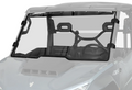 The Segway Fugleman UT10 Scratch Resistant Windshield, a transparent, slightly tinted polycarbonate panel with black mounting brackets and rubber seals, is installed on the front of a blue off-road utility vehicle. The background appears partially faded.