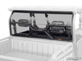 A Segway Fugleman UT10 Rear Windshield made of clear polycarbonate with a frame, mounting brackets, and two adjustable vents is installed on a utility vehicle, viewed from the cargo bed. The SuperATV logo is in the images bottom right corner.