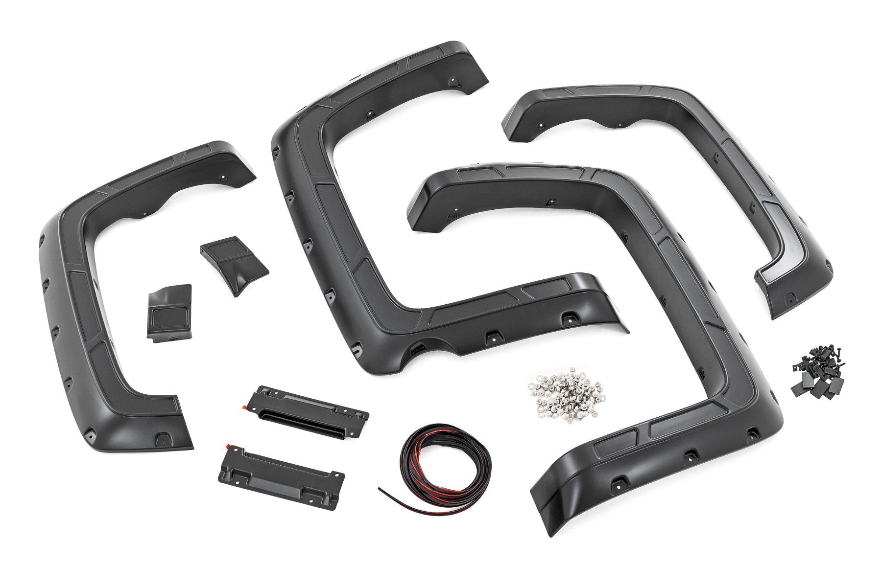 Displayed on a white background are four black plastic fender flares, mounting brackets, screws, wiring, and clips—components from the Fender Flares | Defender 59 Bed kit for Chevy Silverado 1500 2WD/4WD (2014-18 & Classic).