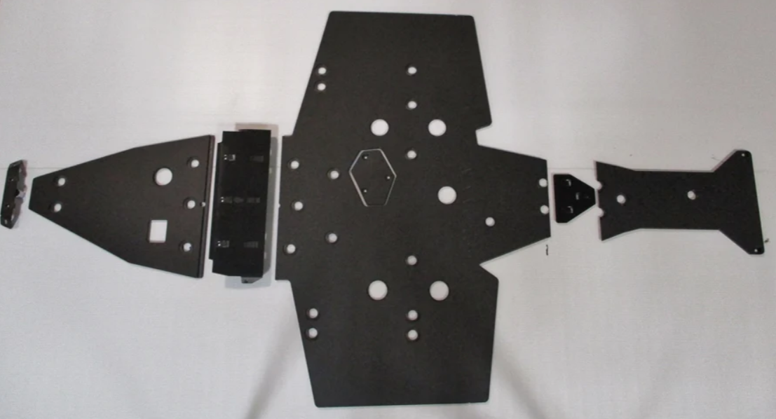Five black metal plates from the Trail Armor Sportsman 850/850 SP/1000 XP Scrambler 850/1000 XP Full Skid set, each with multiple circular cutouts, are arranged in a row with the largest central plate and smaller plates on either side.
