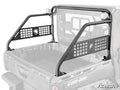 A Can-Am Defender Sport Accessory Bar, featuring black metal construction, mesh panels, cut-out grid designs, and a circular emblem, is installed in the cargo bed of a Can-Am utility vehicle against a white background.
