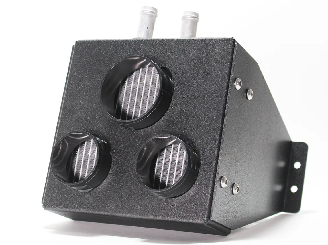 The Inferno Cab Heater Kit With Defrost for 2016-Current Arctic Cat Textron Stampede features a black metal box with three round front vents, two silver pipes on top, side mounting brackets with screw holes, all set against a plain white background.