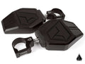 Two black, angular Assault Industries Aviator UTV Side Mirrors with geometric designs and integrated clamp mounts are shown. Each features the ASSAULT logo and a bold V-shaped accent, with one mirror stacked atop the other, both facing left.