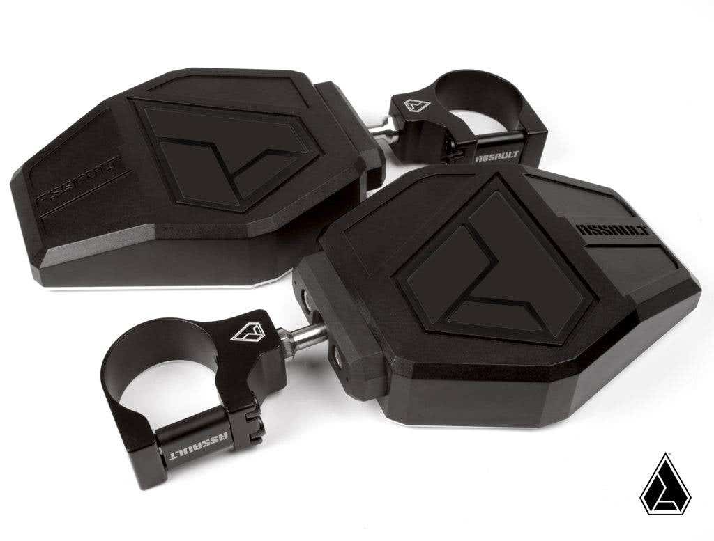 Two black, angular Assault Industries Aviator UTV Side Mirrors with geometric designs and integrated clamp mounts are shown. Each features the ASSAULT logo and a bold V-shaped accent, with one mirror stacked atop the other, both facing left.