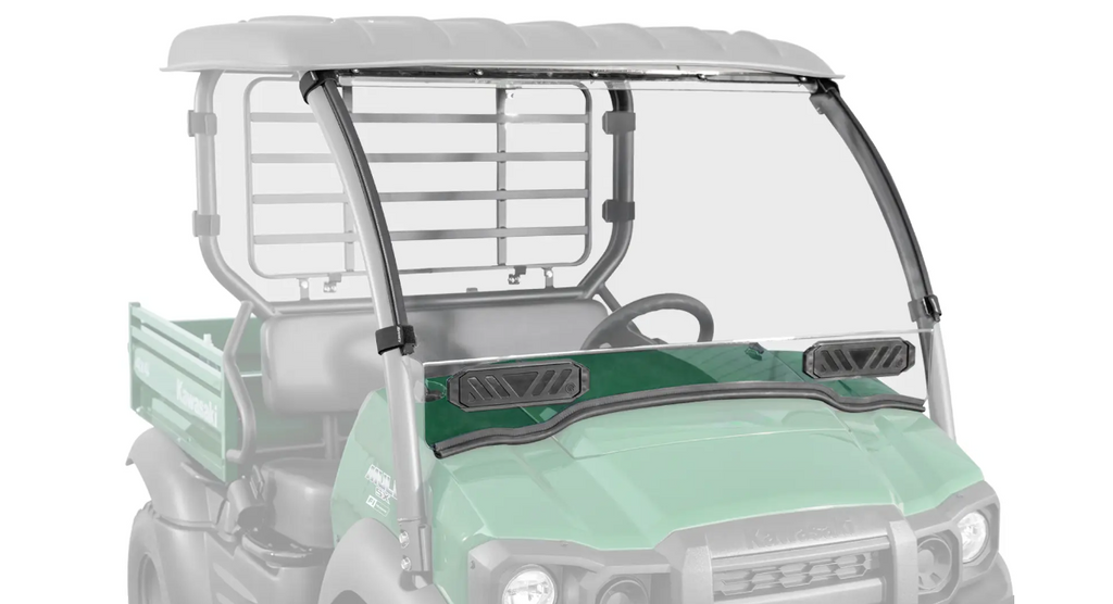 The Kawasaki Mule SX Scratch Resistant Windshield is installed on a green utility vehicle with a black roof. The clear windshield covers the front, features two black ventilation panels, and the rear is faded out to highlight the windshield.