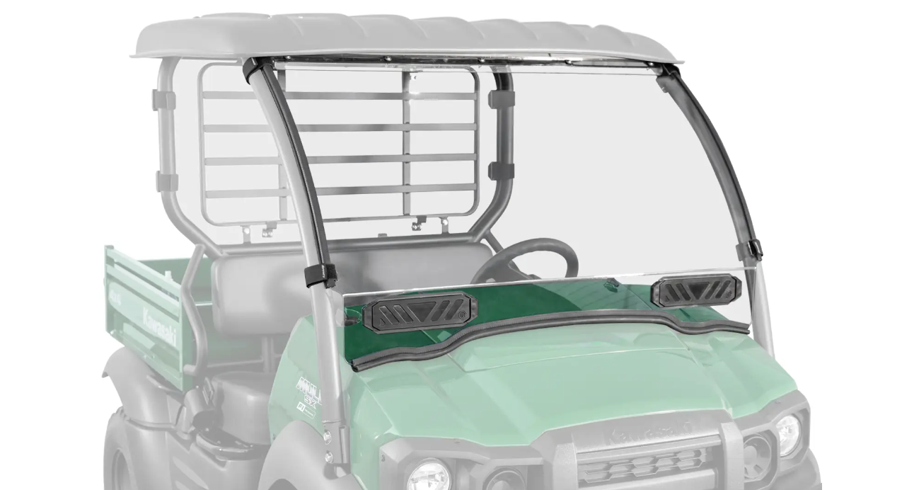 The Kawasaki Mule SX Scratch Resistant Windshield is installed on a green utility vehicle with a black roof. The clear windshield covers the front, features two black ventilation panels, and the rear is faded out to highlight the windshield.