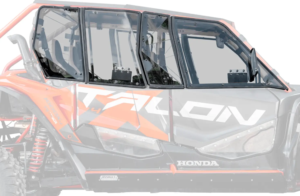 A close-up side view of a Honda Talon 1000-4 with Hard Cab Enclosure Doors installed shows clear windows, visible suspension, and an orange, black, and white body with TALON boldly displayed on the side.
