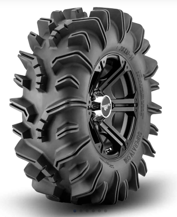 The SuperATV Terminator Mud Tire is shown upright, mounted on a black alloy wheel with bold spokes and a branded center cap. Its large, black design features deep, aggressive treads for heavy traction. The background is plain white.