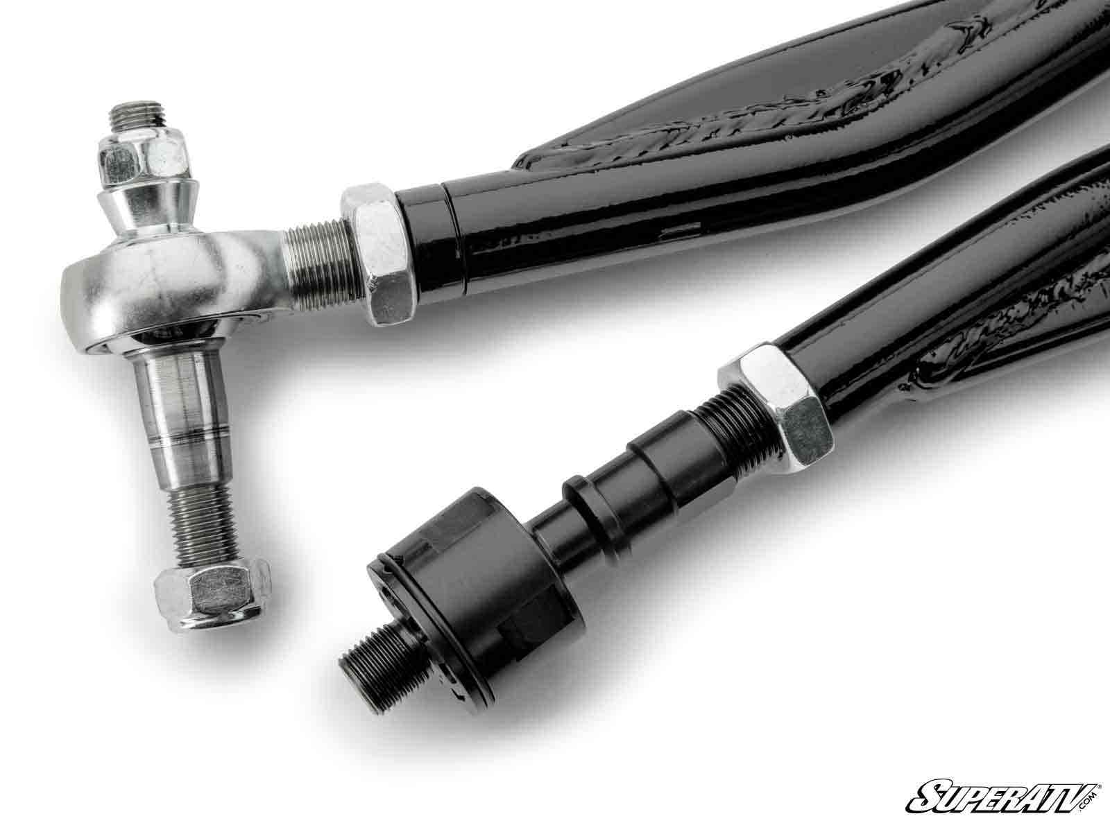Close-up of two black metal rods from the Can-Am Defender HD8 RackBoss 2.0 Z-Bend Tie Rod Kit, showing threaded ends with silver hex nuts, a joint, a rod end bearing on one side, and a black fitting on the other. SuperATV logo in lower right corner.